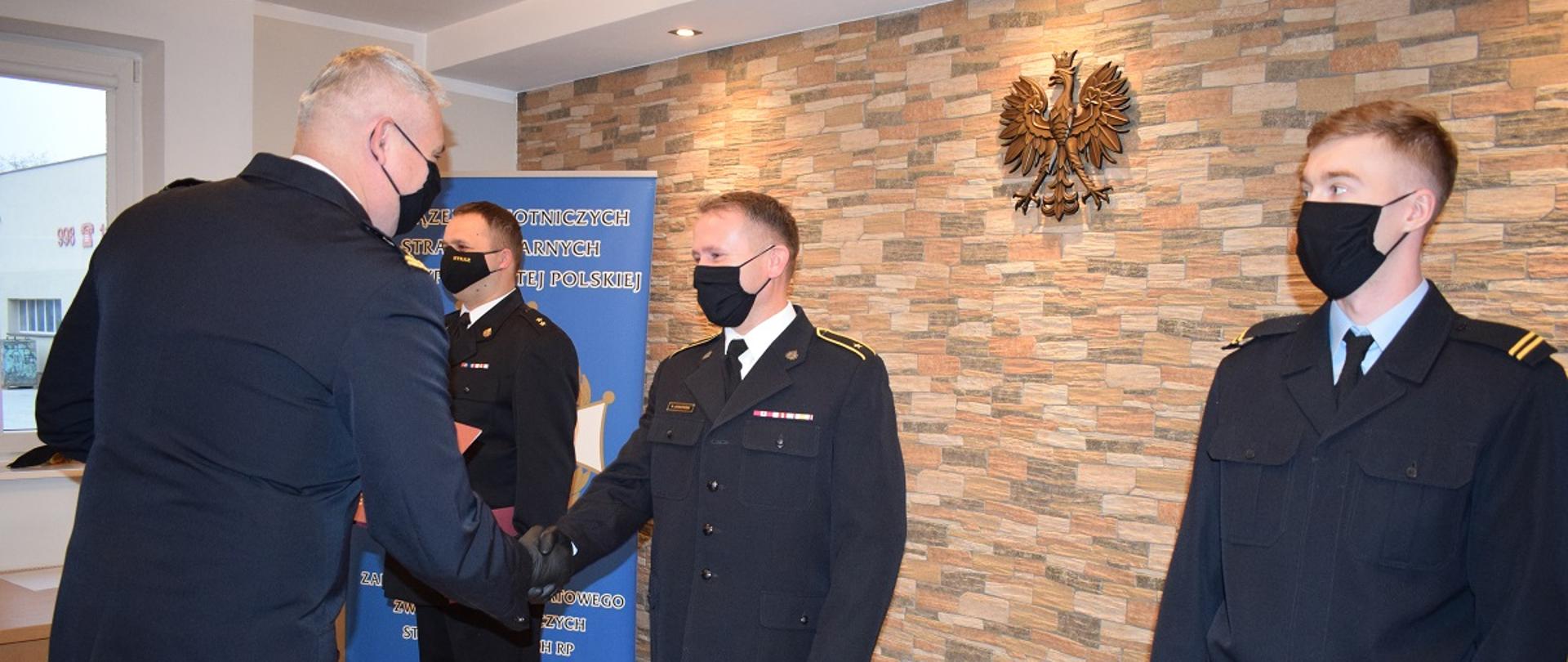 Wręczenie nagród i awansów. Komendant wręcza wyróżnienie.