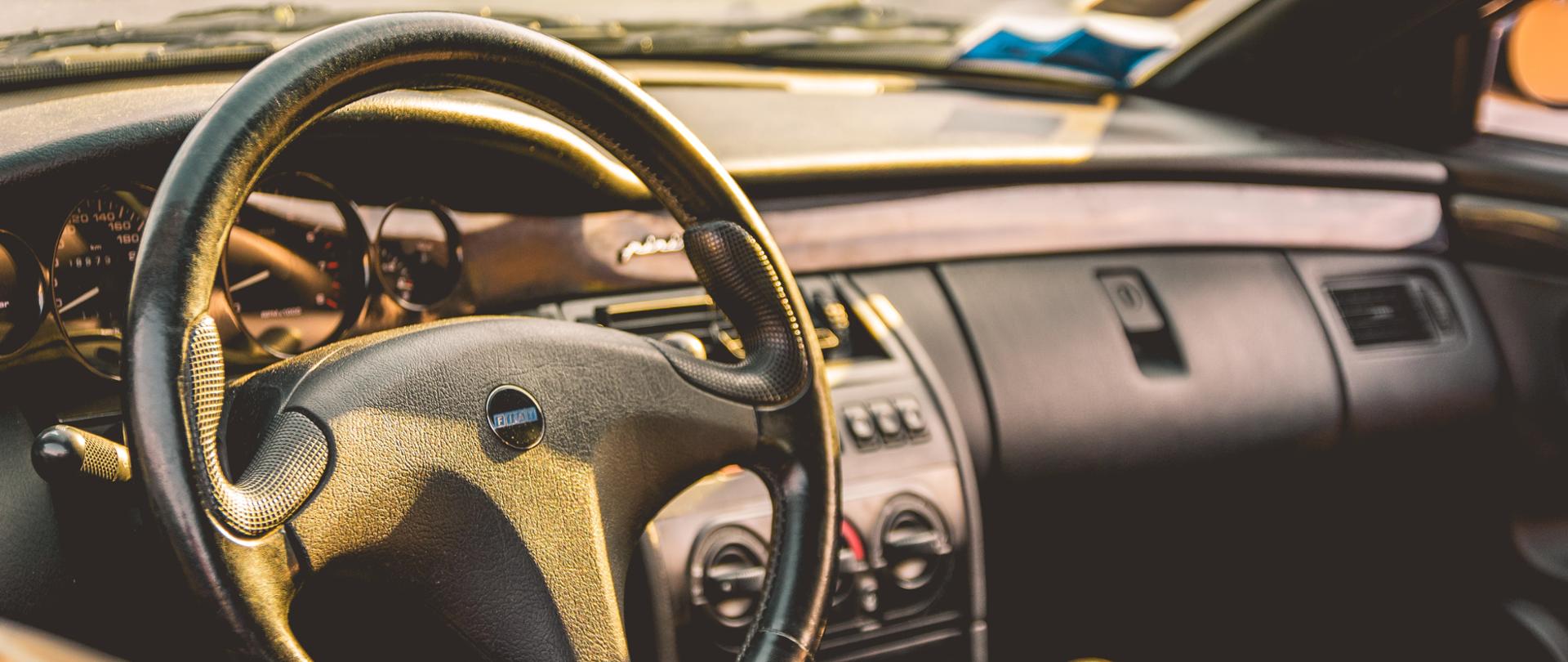 wnętrze samochodu fiat, na zdjęciu widać tablicę rozdzielczą, kierownicę, sprzęgło