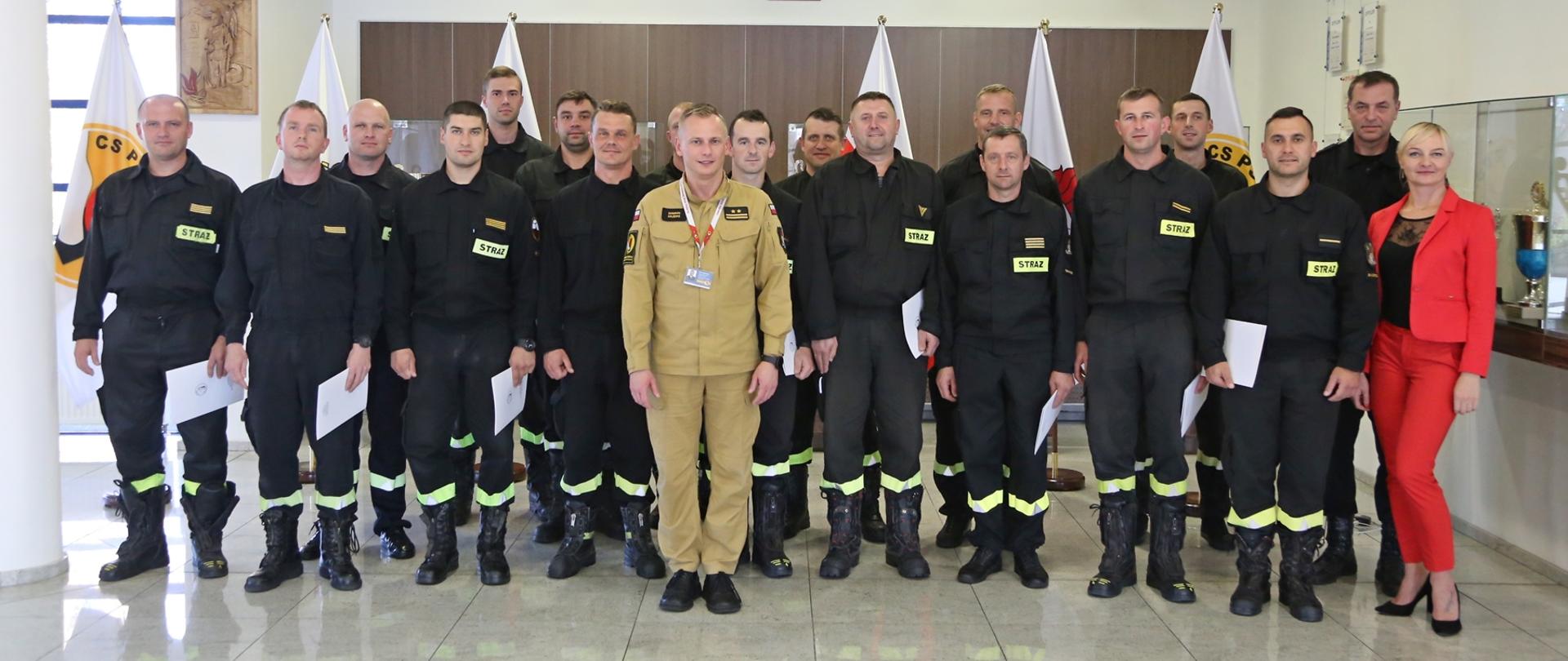 Grupowe zdjęcie uczestników szkolenia (16 strażaków) w towarzystwie Zastępcy Komendanta Centralnej Szkoły PSP, naczelnika wydziału technicznego CS PSP oraz pracownicy wydziału szkoleń specjalistycznych i współpracy międzynarodowej