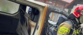 Strażak przy spalonym samochodzie