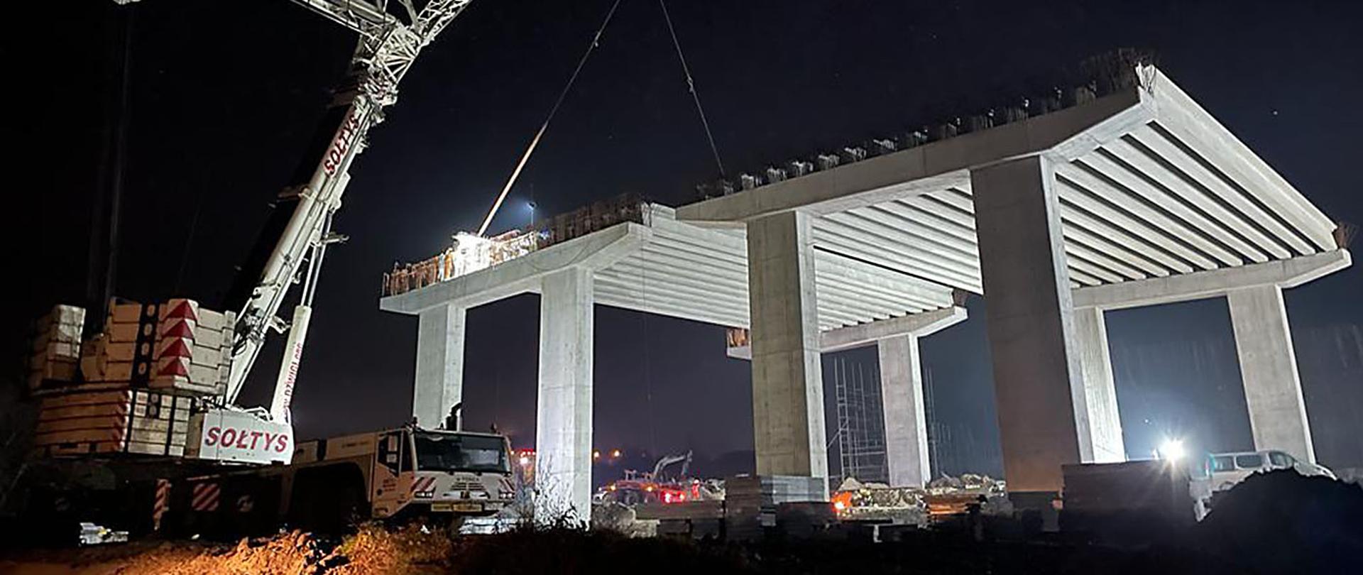 Budowa S52 Północnej Obwodnicy Krakowa. Na pierwszym planie dźwig budowlany i podpory wiaduktu, na których układane są prefabrykowane belki.