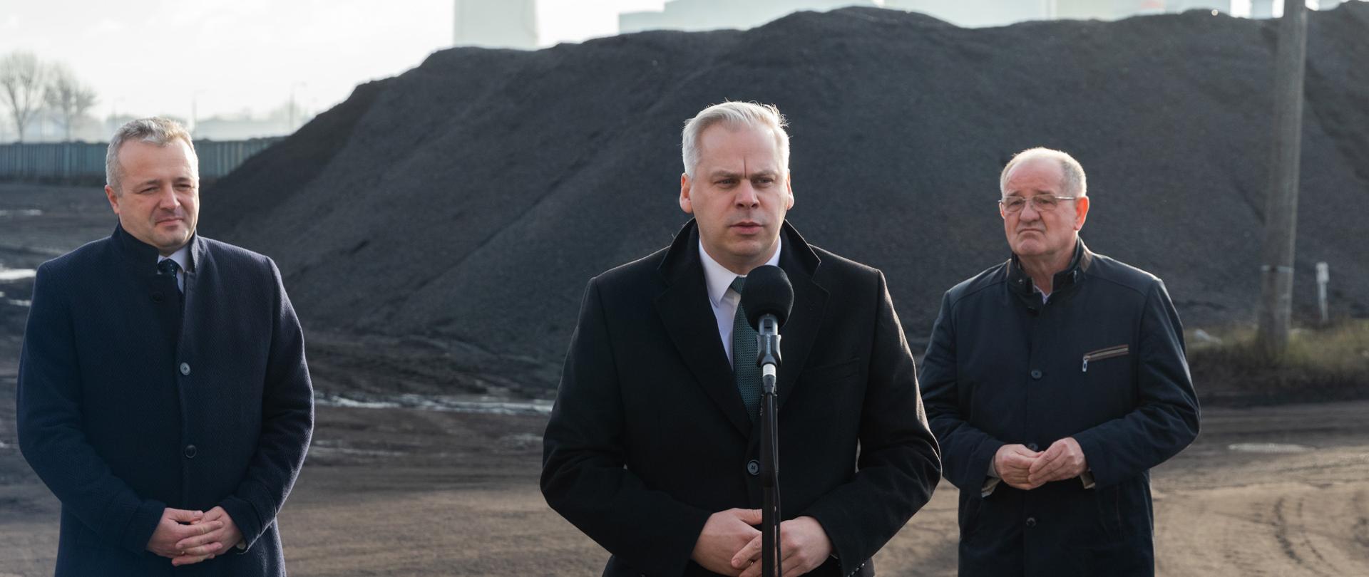 
Mężczyźni stojący na tle góry węgla
