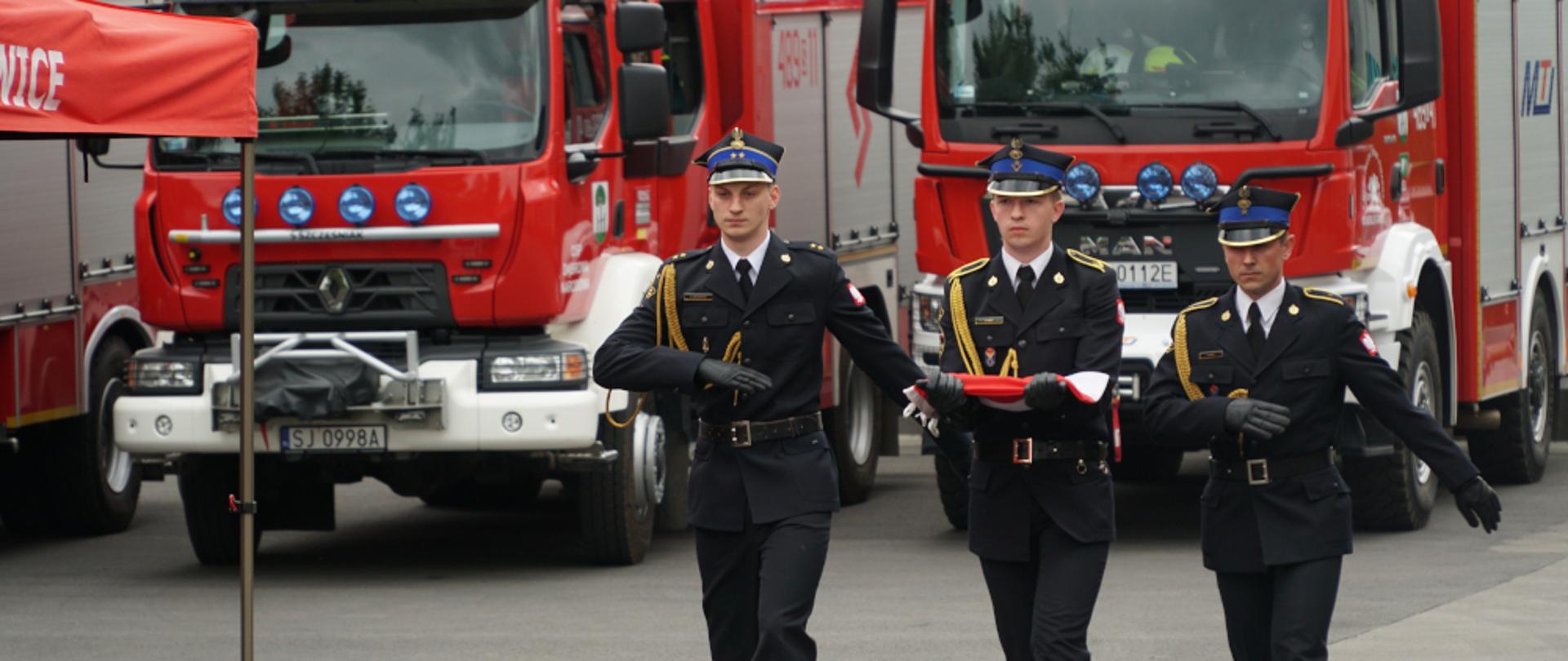 Zdjęcie przedstawia poczet flagowy maszerujący do wywieszenia flagi państwowej.