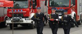 Zdjęcie przedstawia poczet flagowy maszerujący do wywieszenia flagi państwowej.