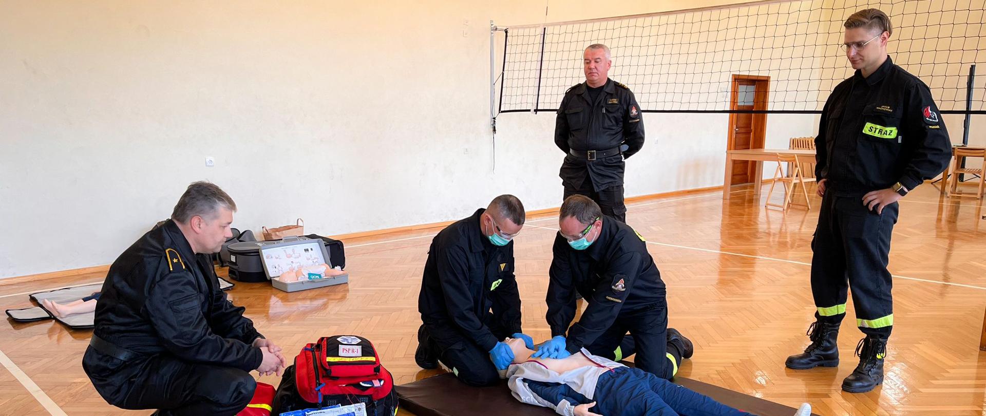 Strażacy wykonują czynności z zakresu kwalifikowanej pierwszej pomocy na manekinie
