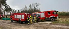 Zdjęcie przedstawia druhów oraz pojazdy pożarnicze w trakcie ćwiczeń. 