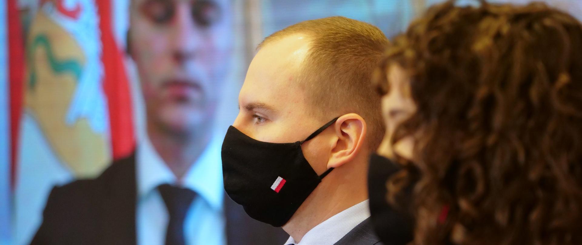 Zbliżenie - minister Adam Andruszkiewicz i Justyna Orłowska podczas konferencji prasowej. Zdjęcie z profilu - oboje w maseczkach.