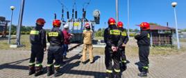 Szkolenie w zakresie zagrożeń ze strony urządzeń elektroenergetycznych. Zdjęcie przedstawia strażaków PSP oraz pracowników firmy Energa podczas szkolenia.