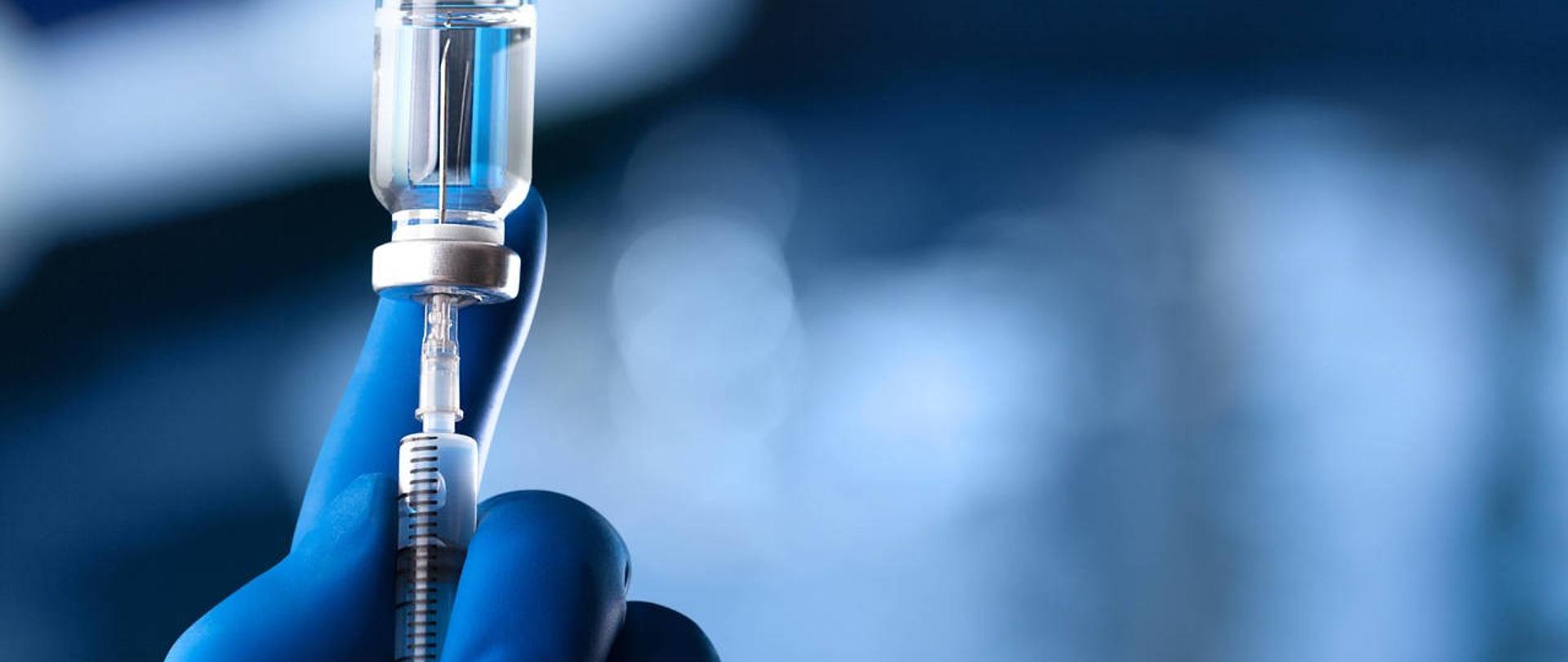 Dłoń trzymająca strzykawkę z ampułką - baner