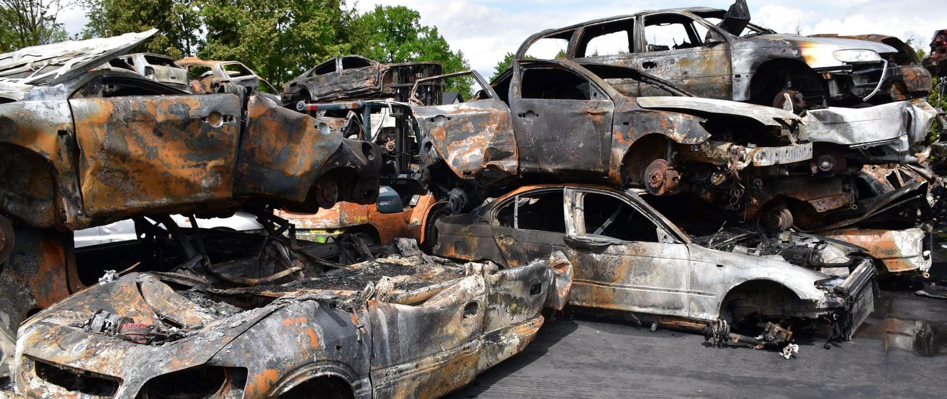 Spalone pojazdy ustawione jeden na drugim w kilku rzędach