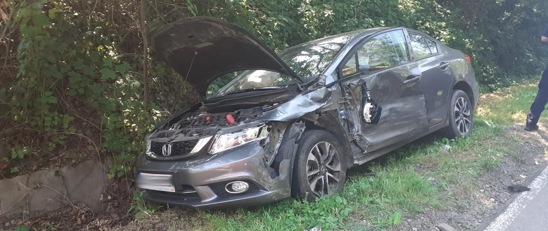 Samochód osobowy z otwartą klapą silnika poza drogą