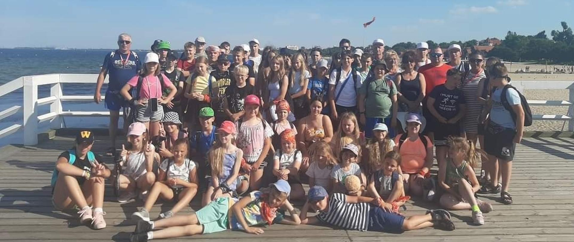 widoczni uczestnicy wypoczynku na pomoście nad morzem