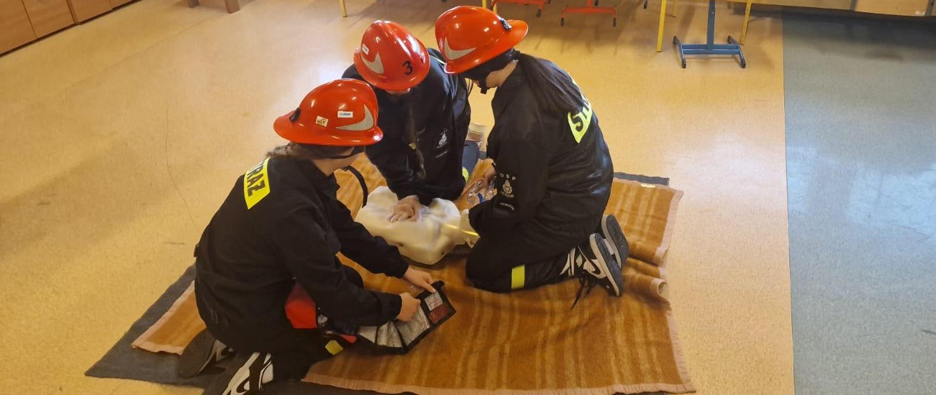 Dzieci ćwiczące pomoc na manekinie