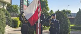 Strażacy wciągają Flagę Państwową na maszt.