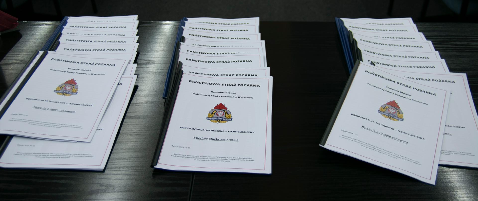 Leżące na stole skrypty będące dokumentacją techniczno-technologiczną nowego umundurowania