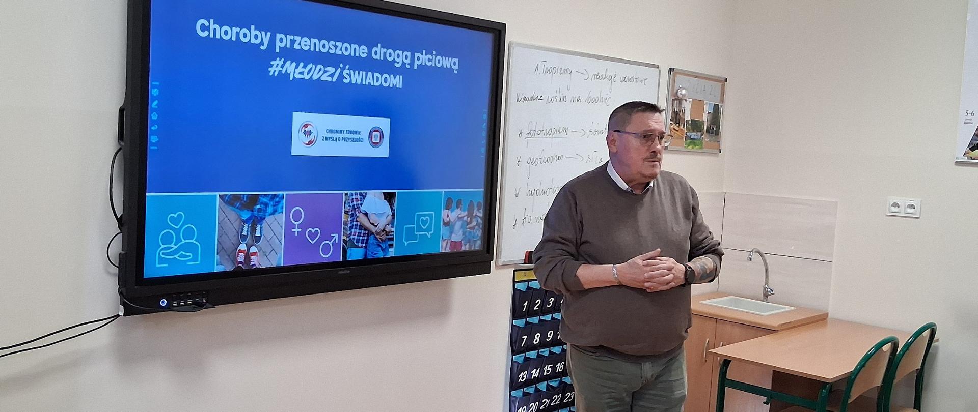 Prelegent przy prezentacji multimedialnej dotyczącej programu #MłodziŚwiadomi