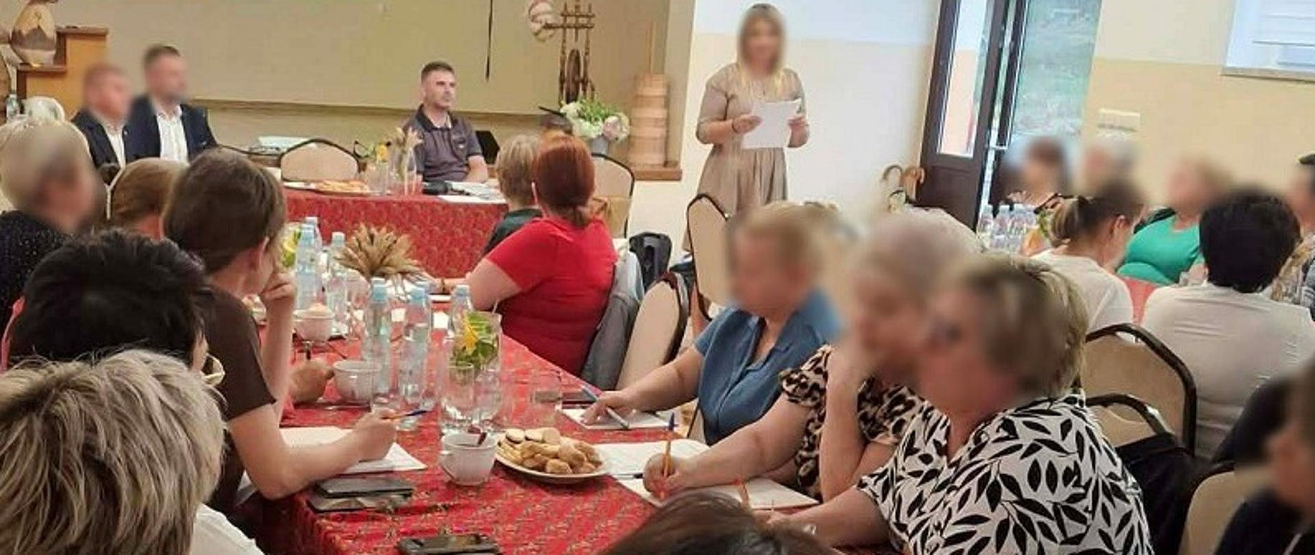 Uczestnicy siedzą w sali. Przed nimi są organizatorzy spotkania, w tym ekspert podkarpackiej KAS. 