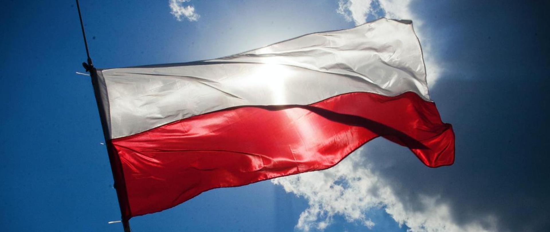 polska flaga na tle błękitnego nieba