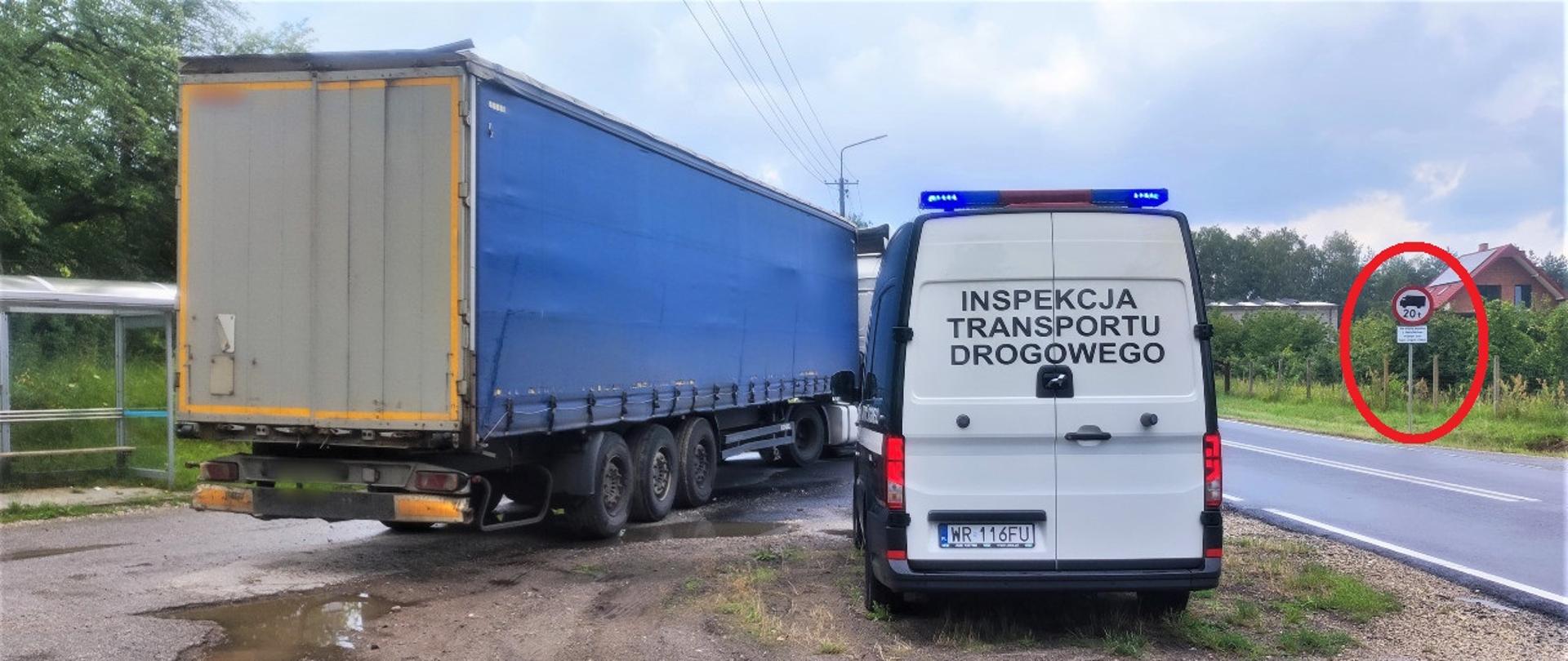 Na pierwszym planie (od lewej): tył ciągnika siodłowego z naczepą kurtynową. Obok kontrolowanego zestawu ciężarowego stoi oznakowany furgon mazowieckiej Inspekcji Transportu Drogowego z włączonymi niebieskimi światłami uprzywilejowania w ruchu drogowym. W tle: stojący przy drodze znak ograniczenia tonażowego. 