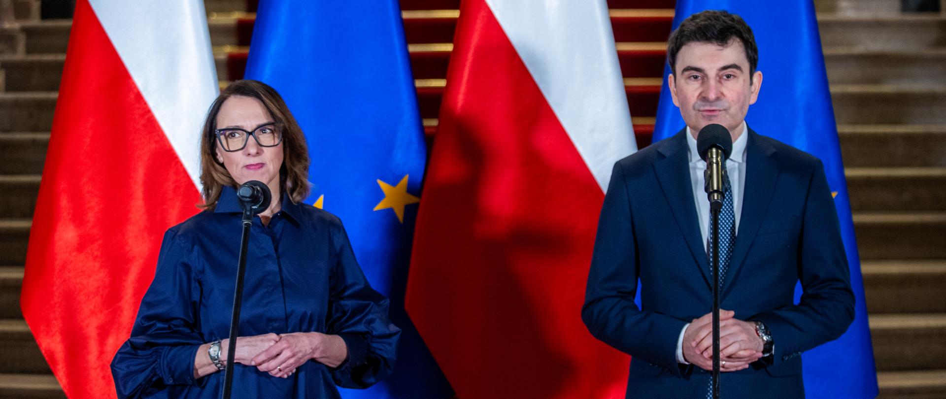 Aleksandra Dyla i wojewoda śląski Marek Wójcik stoją na tle flag Polski i UE