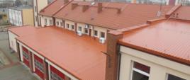 Zdjęcie przedstawia budynek Komendy Państwowej Straży Pożarnej w Ostrzeszowie. Na pierwszym planie widoczny wyremontowany dach strażnicy.