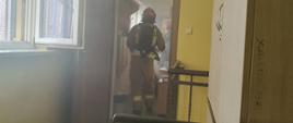 Na zdjęciu strażacy ewakuują poszkodowanego z zadymionego pomieszczenia