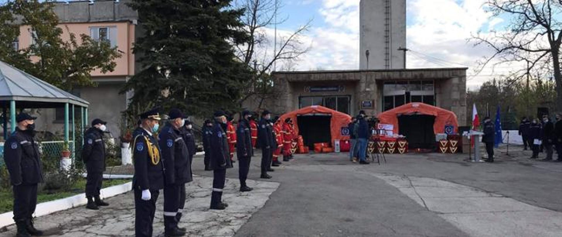 men in uniforms are standing in a row before red tents