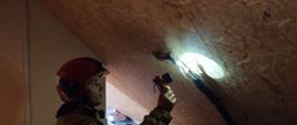 Strażak oświetla miejsce nieszczelności