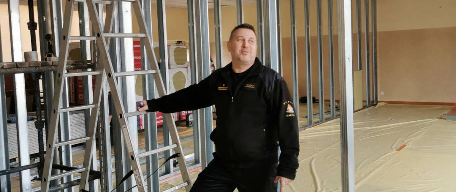 Funkcjonariusz PSP na tle konstrukcji stelażowej ściany.