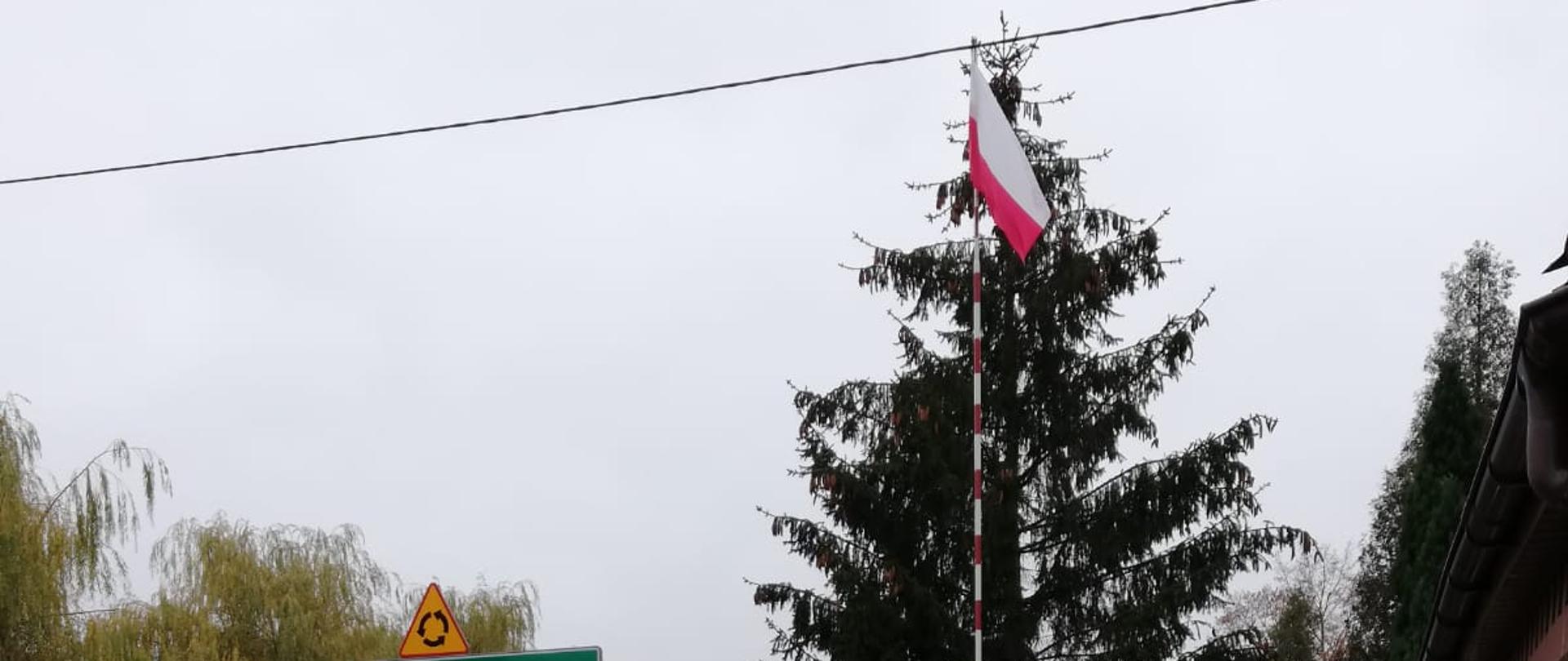 Zdjęcie przedstawia wciągnięcie flagi na maszt w Dniu Święta Niepodległości przed budynkiem KP PSP Pajęczno.