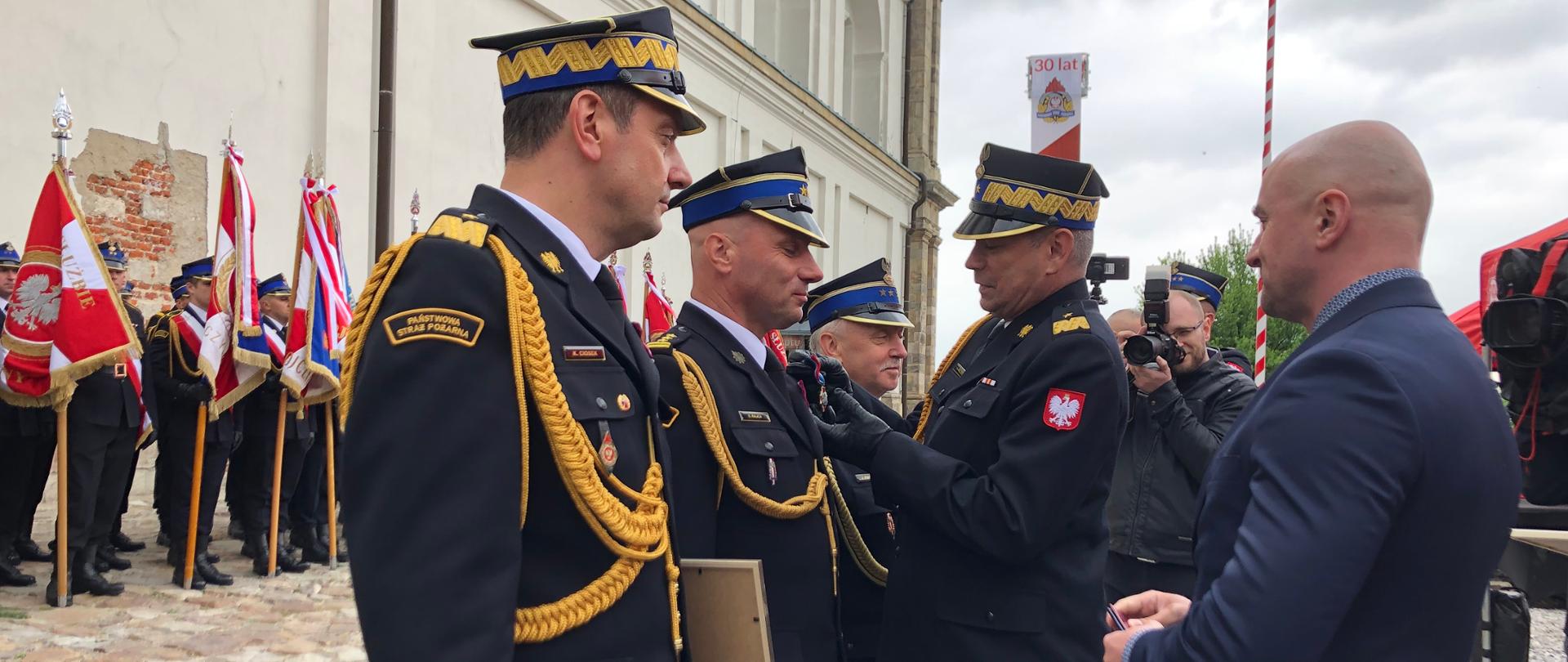 Na zdjęciu zastępca komendanta głównego PSP przypina medal strażakowi PSP 