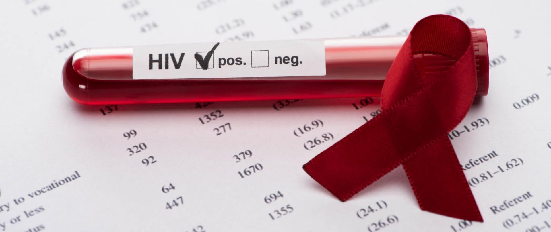 Na zdjęciu jest test na HIV i czerwona wstążka.