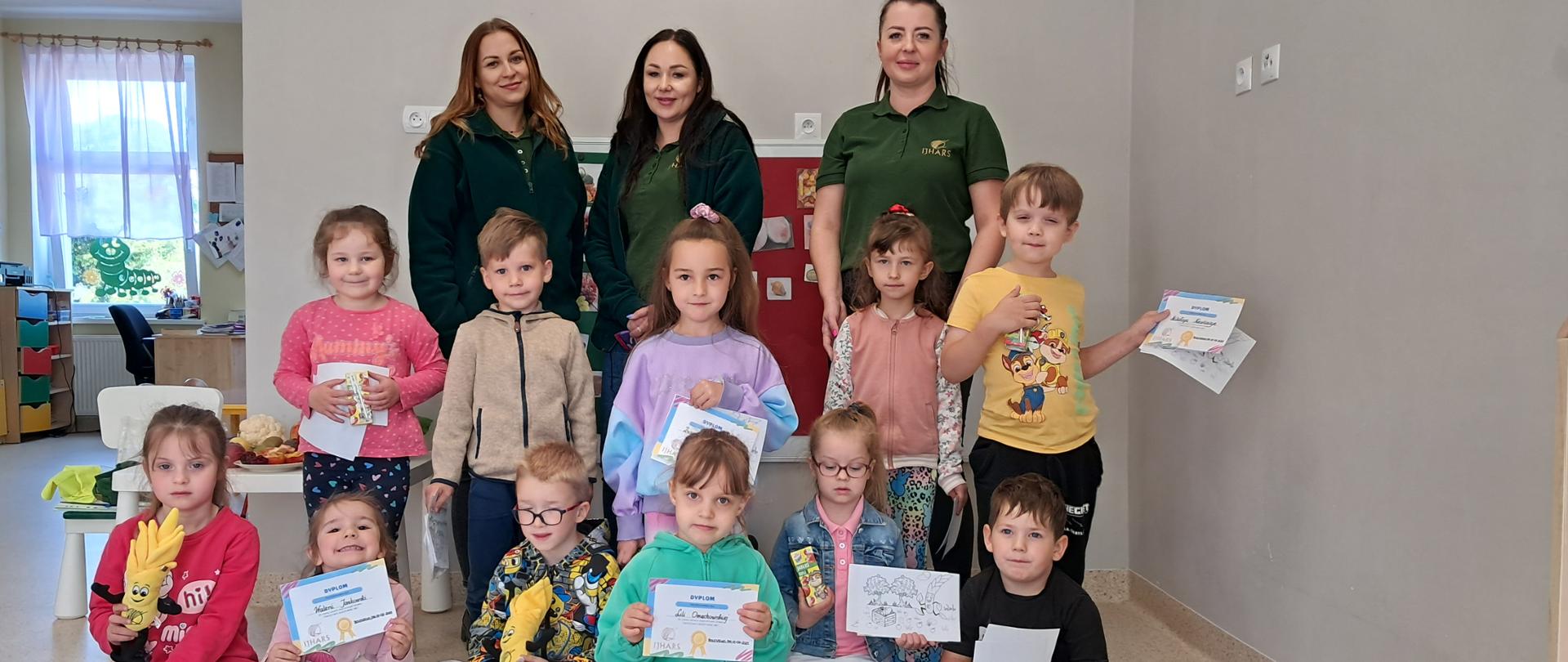 Inspektorki IJHARS i dzieci na wspólnym zdjęciu. W rękach trzymają dyplomy.