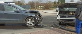Zdjęcie przedstawia dwa auta osobowe po zderzeniu czołowym w miejscowości Świdwin. Jedno auto koloru szarego znajduje się na swoim pasie jezdni zaś drugie koloru białego na przeciwnym pasie ruchu. Na drodze znajdują się rozbite elementy pojazdu takie jak: reflektory, zderzaki, szkło, elementy plastikowe pojazdu. W tle zdjęcia widać średni samochód ratowniczo-gaśniczy z włączonymi światłami mijania oraz błyskowymi jaki i strażaków.