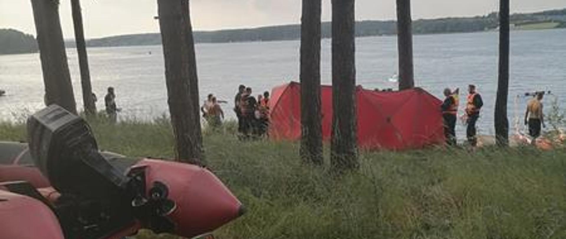 Udzielanie kwalifikowanej pierwszej pomocy osobie wyciągniętej z wody. Działania powadzone na brzegu zalewu za parawanem