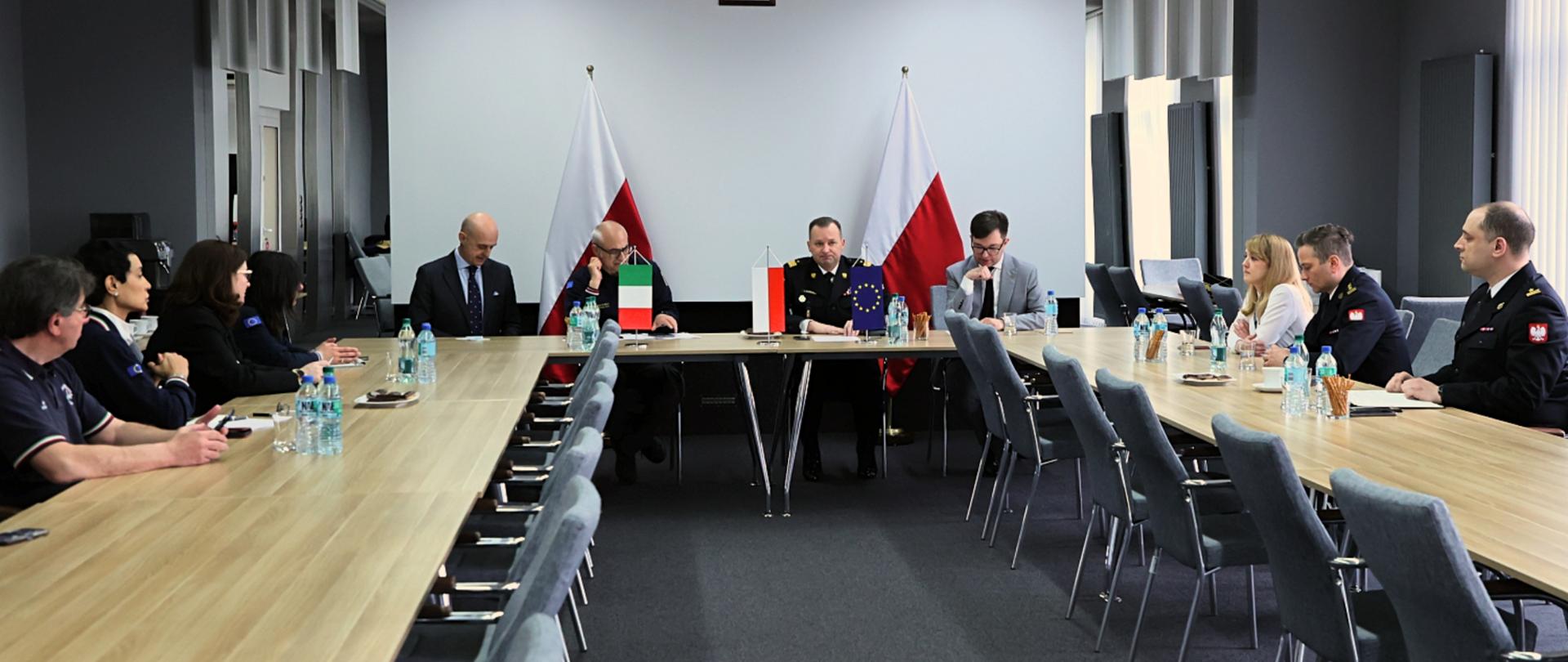 Sala konferencyjna, plan ogólny. Uczestnicy spotkania siedzący za stołem konwencyjnym. 