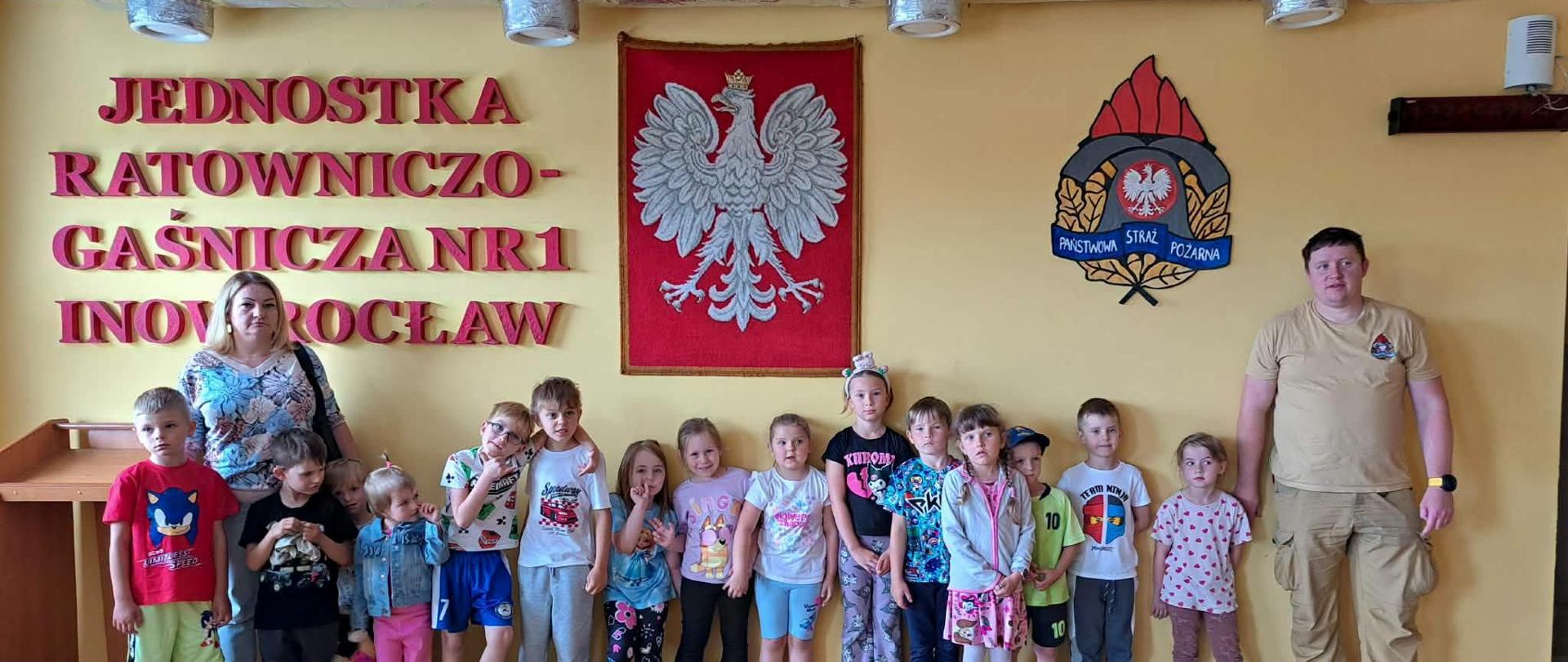 Dzieci z punktu i oddziału przedszkolnego na sali sportowej Jednostki Ratowniczo Gaśniczej nr 1 oprowadzani przez asp. Macieja Małkowicza