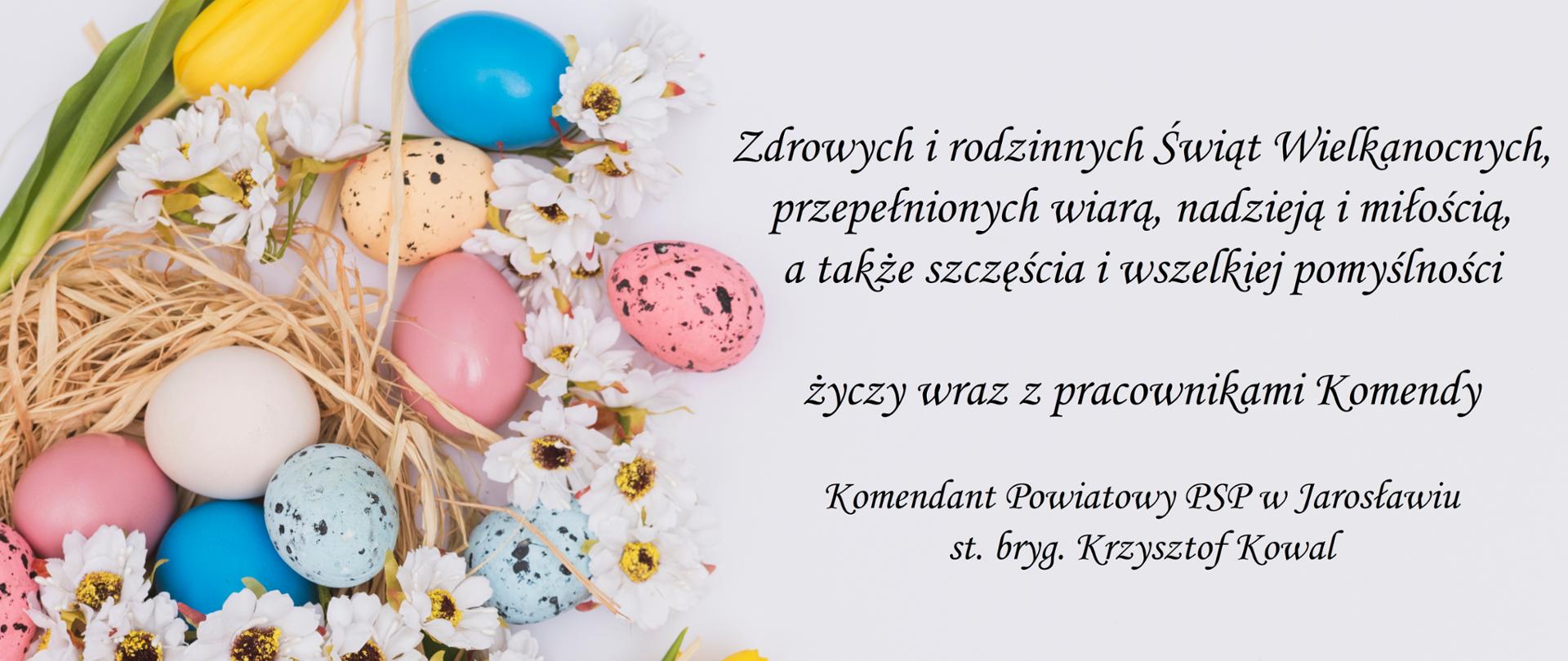 Obraz przedstawia koszyczek wielkonocny, który znajduje się po lewej. W koszyczku znajdują się pisanki i kwiaty. Po prawej stronie zamieszczono życzenia o treści: "Zdrowych i rodzinnych Świąt Wielkanocnych, przepełnionych wiarą, nadzieją i miłością, a także szczęścia i wszelkiej pomyślności życzy wraz z pracownikami Komendy Komendant Powiatowy PSP w Jarosławiu st. bryg. Krzysztof Kowal".
