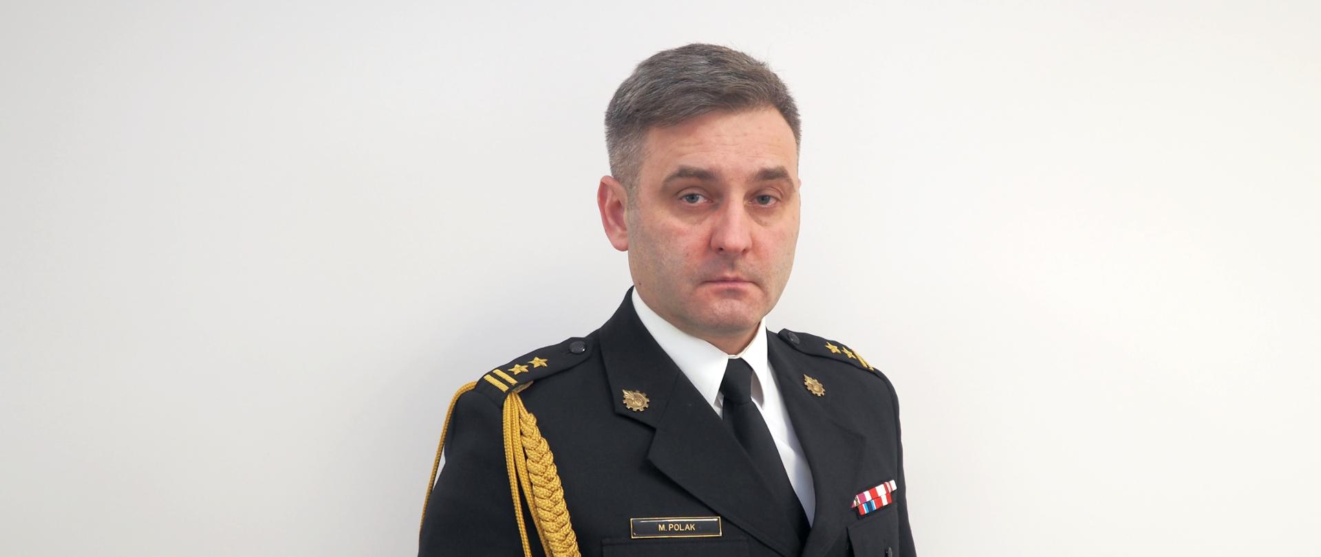 Zdjęcie portretowe Zastępcy Komendanta Powiatowego brygadiera Michała Polaka w mundurze galowym ze sznurem 
