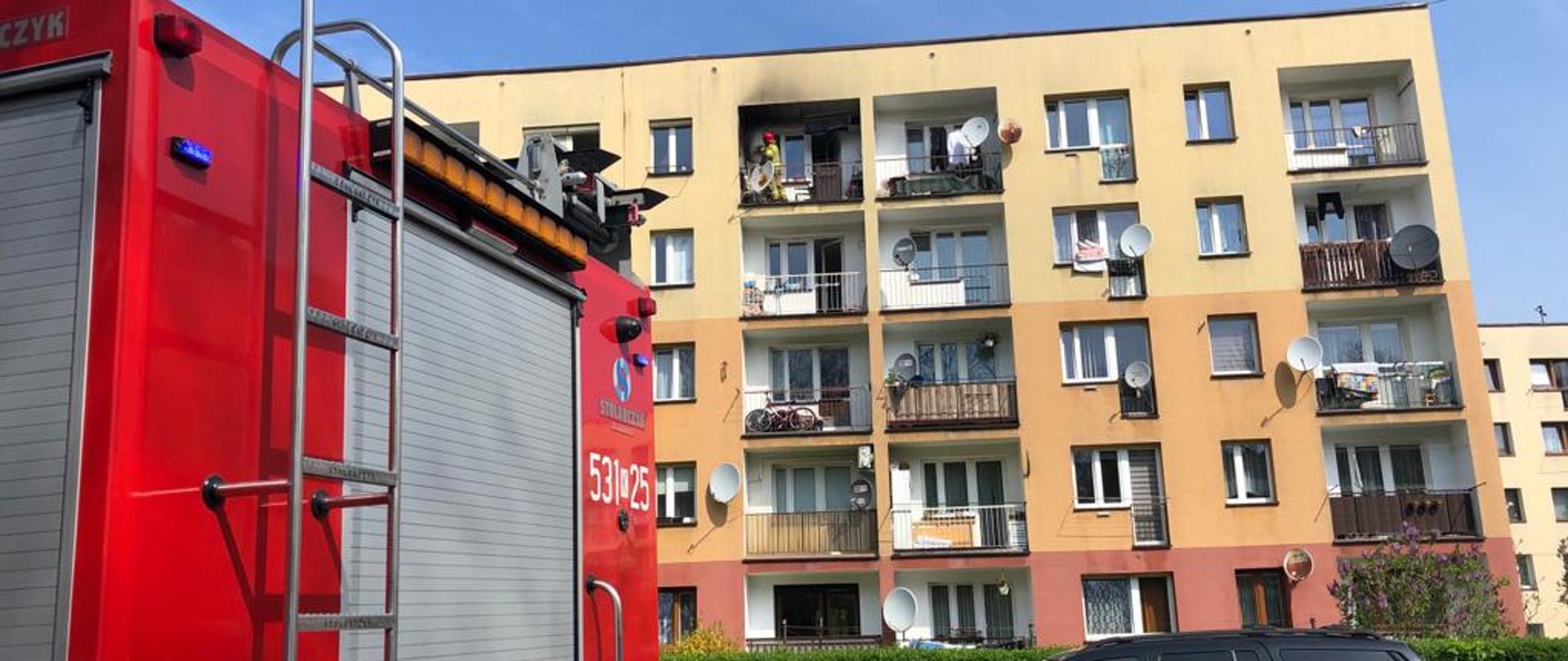 Zdjęcia przedstawia blok oraz tył samochodu pożarniczego