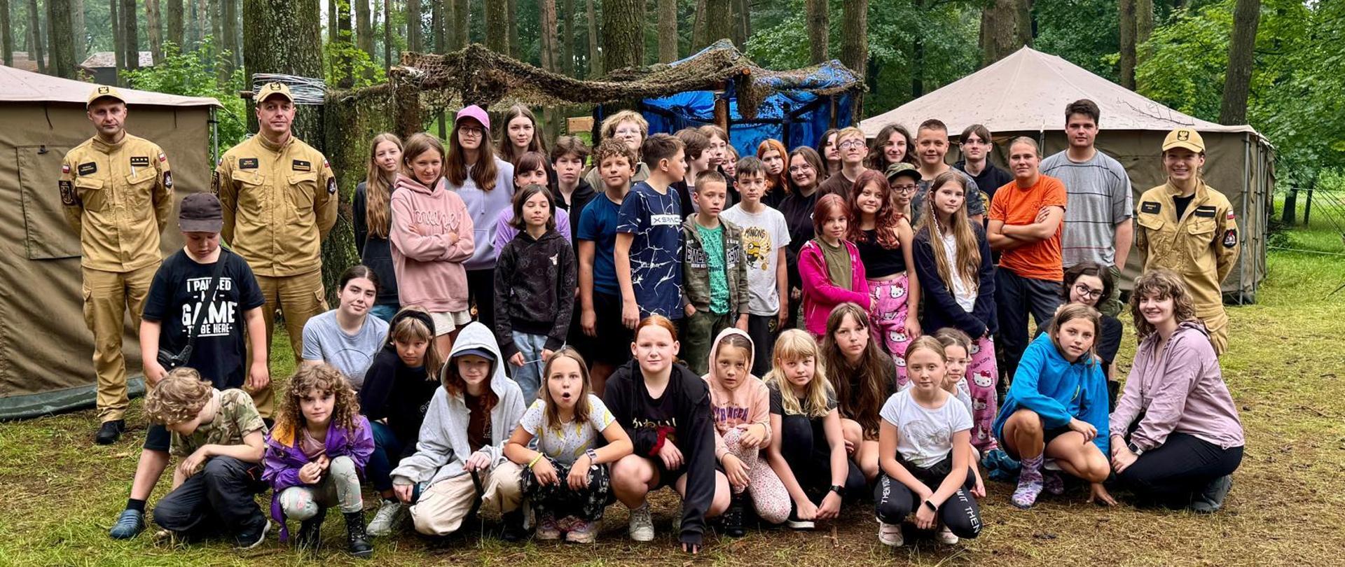 Strażacy z KP PSP w Kwidzynie pozują do zdjęcia z harcerzami.