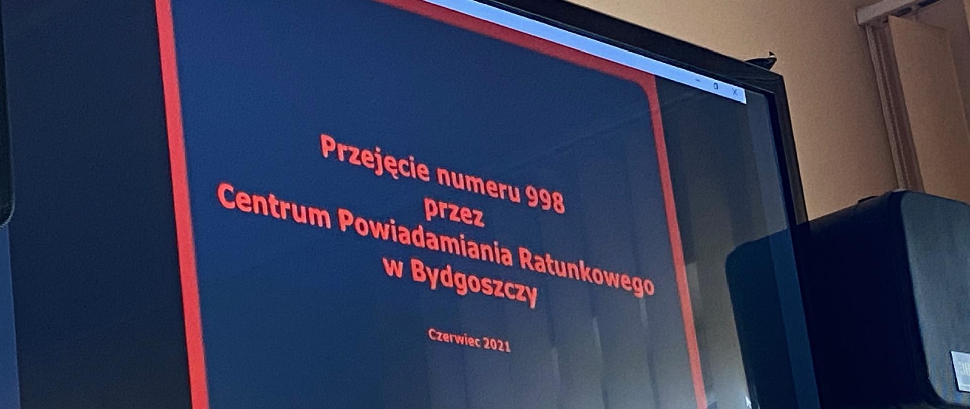 Na zdjęciu kadr z prezentacji, wyświetlony na monitorze. Informacja: Przejęcie numeru 998 przez CPR.