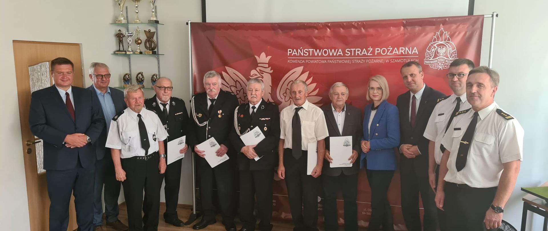 Zdjęcie grupowe po wręczeniu decyzji, widać wyróżnione osoby, Wojewodę Wielkopolskiego, Posłów na Sejm RP, Z-cę Komendanta Wojewódzkiego, Komendanta Powiatowego