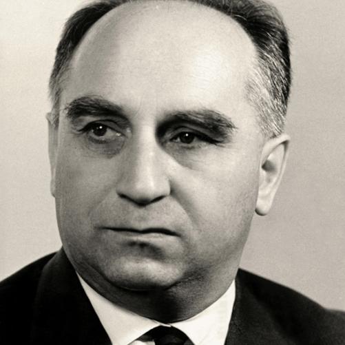 Stefan Jędrychowski czarno - biały portret łysiejącego mężczyzny, ciemne włosy, ciemna marynarka, ciemny krawat, biała koszula.