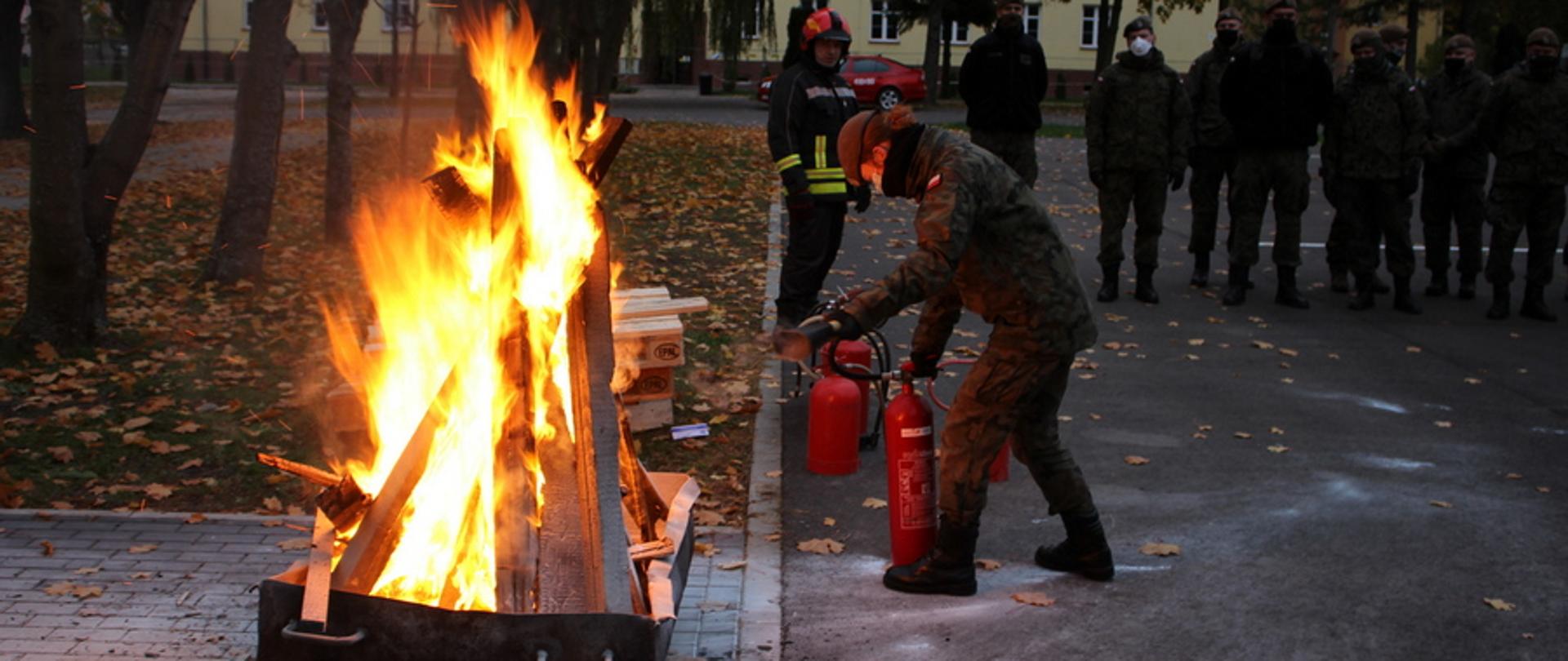 Kobieta w mundurze gasi ogień w specjalnie przygotowanej wannie