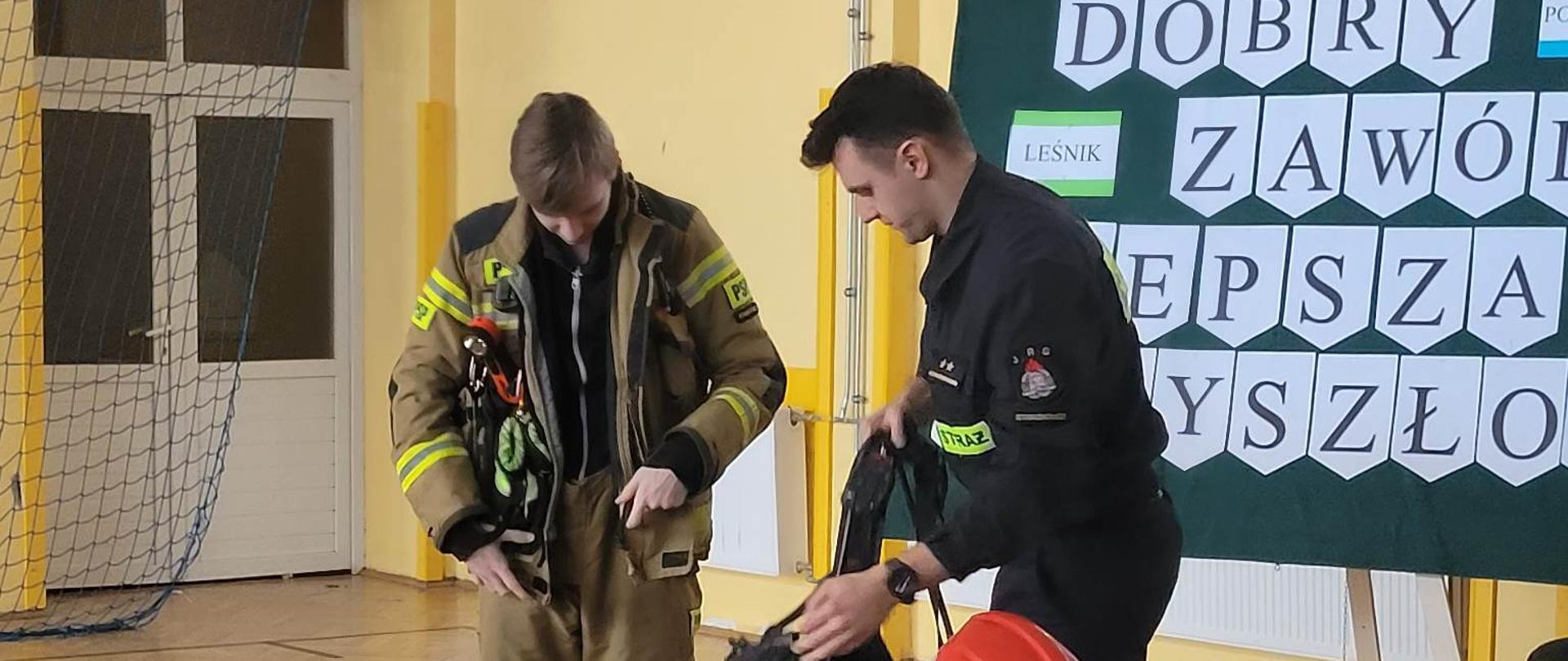 Prezentacja sprzętu przez strażaka dla ucznia szkoły podstawowej