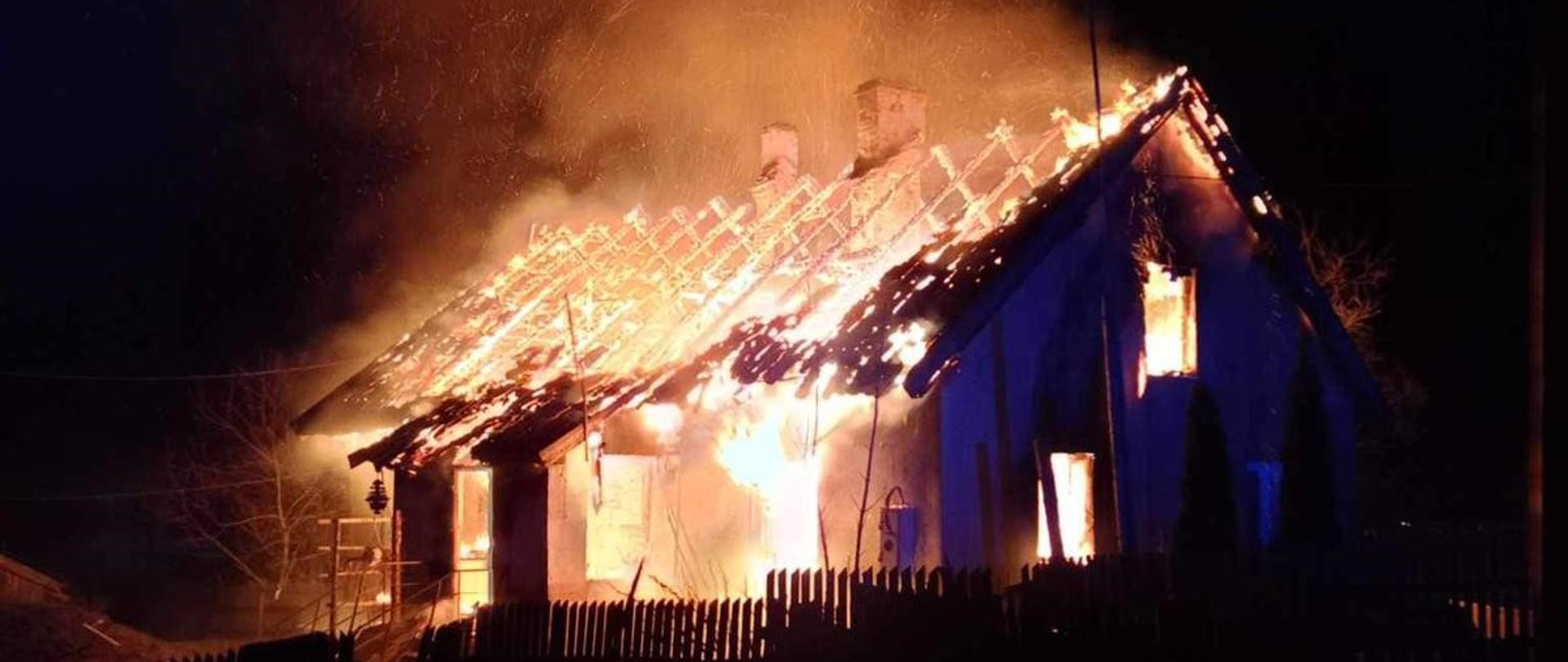 Zdjęcie przedstawia budynek mieszkalny jednorodzinny całkowicie objęty pożarem