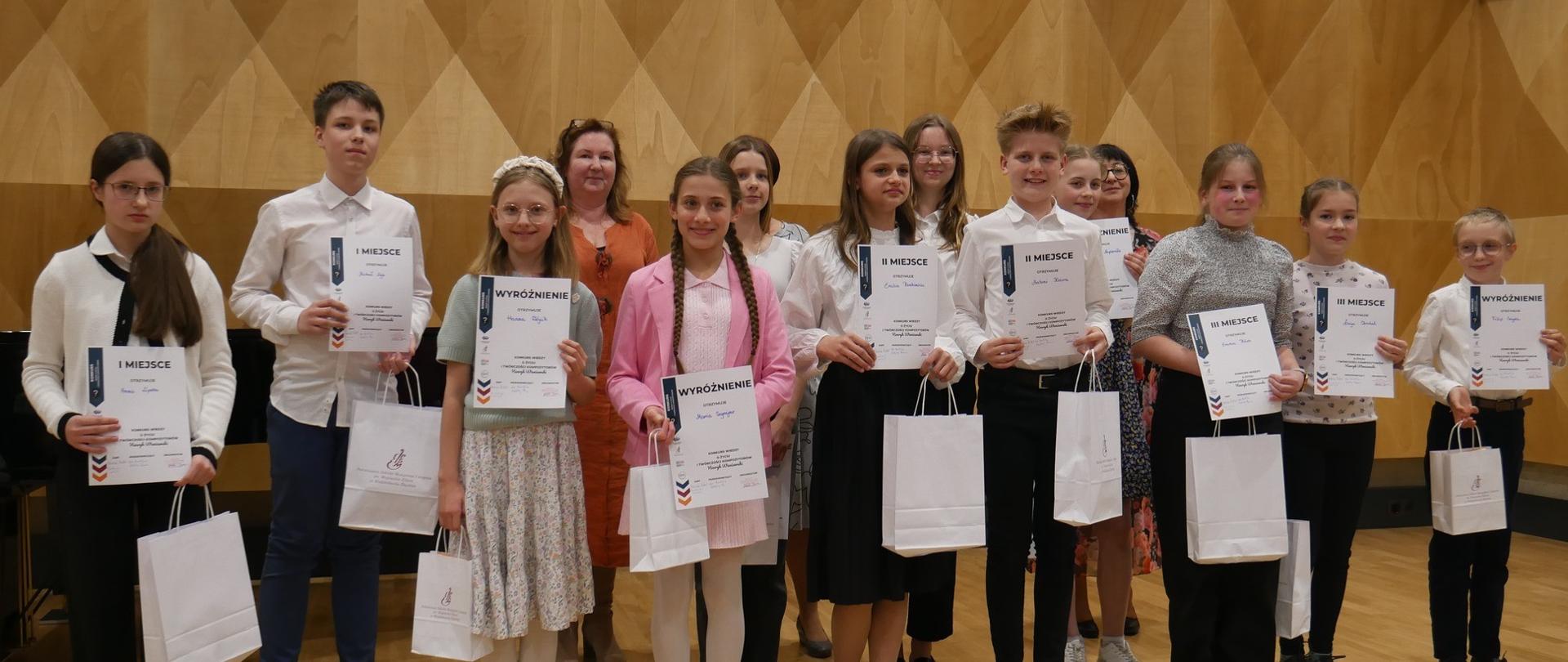 Zdjęcie Laureatów z dyplomami i nagrodami Konkursu Wiedzy o Życiu i Twórczości Kompozytorów Henryk Wieniawski w Wodzisławiu Śląskim dnia czternastego kwietnia dwa tysiące dwudziestego piątego roku