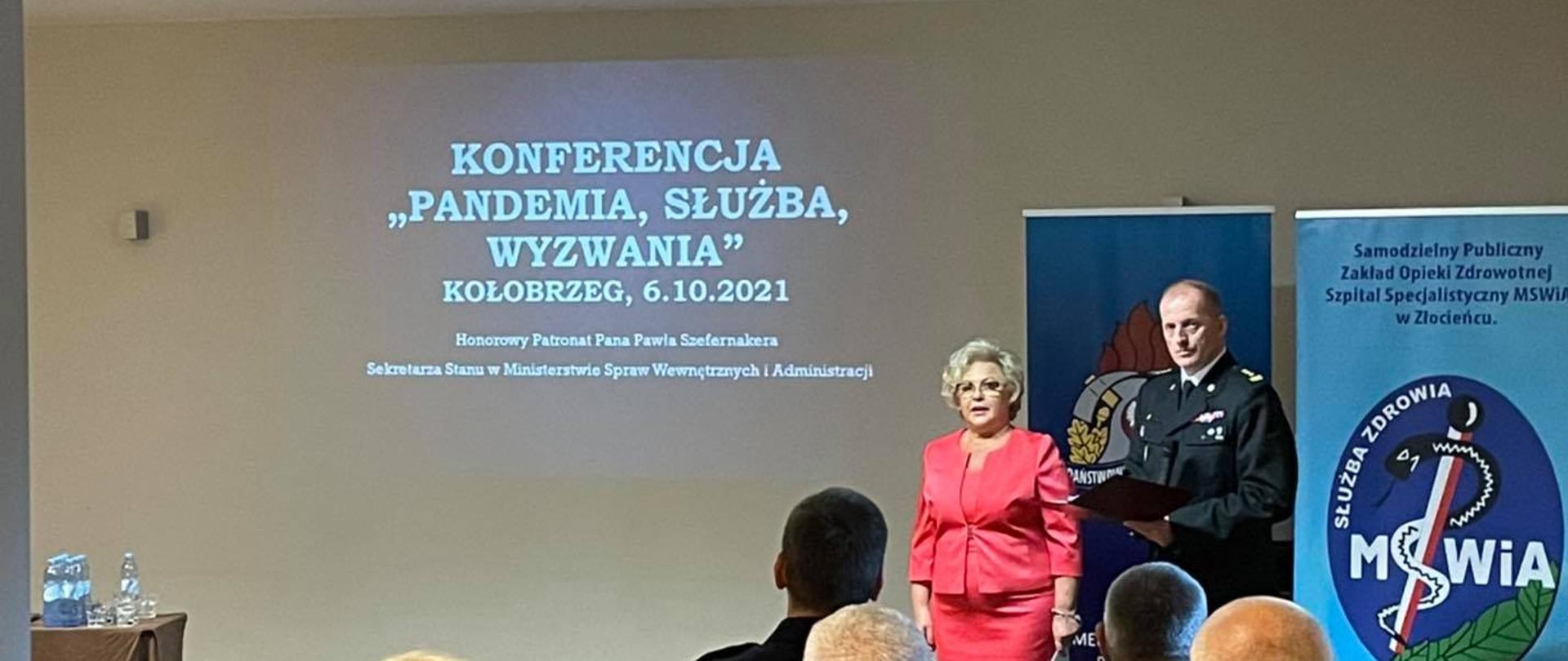 Rozpoczęcie konferencji przez Zachodniopomorskiego Komendanta Wojewódzkiego PSP st. bryg. Jarosława Tomczyka oraz dr Ewę Gizę Dyrektor Szpitala Specjalistycznego MSWiA w Złocieńcu. Na tle banerów oraz wyświetlonego slajdu na ścianie