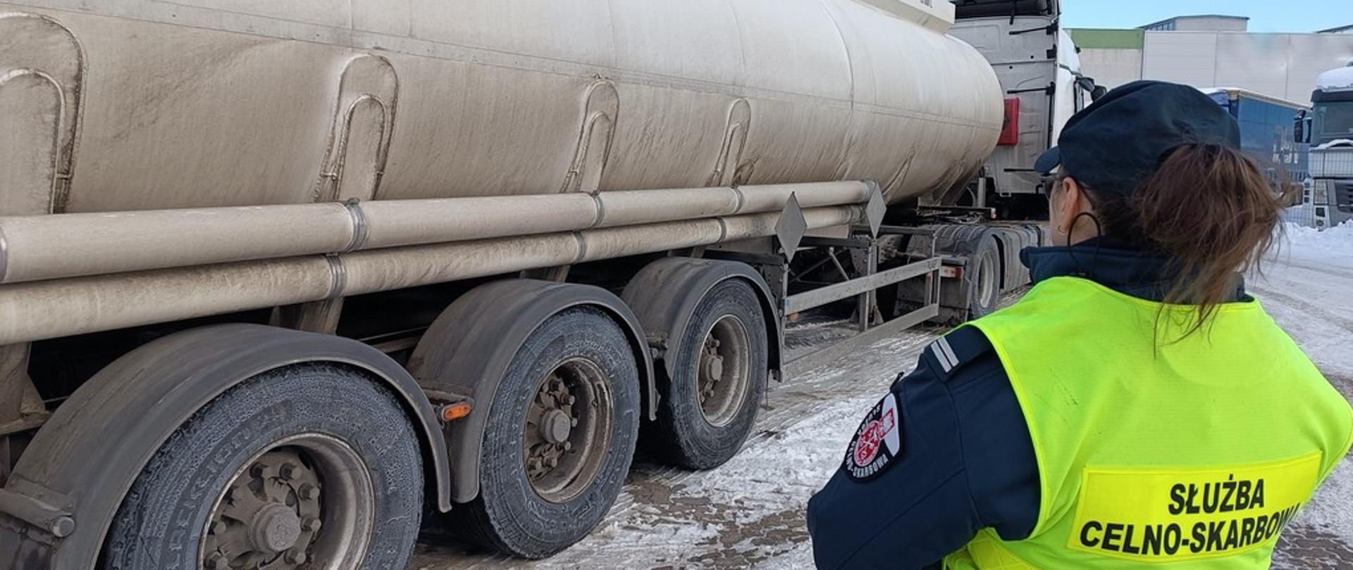 Funkcjonariuszka Służby Celno‑Skarbowej stoi obok cysterny.